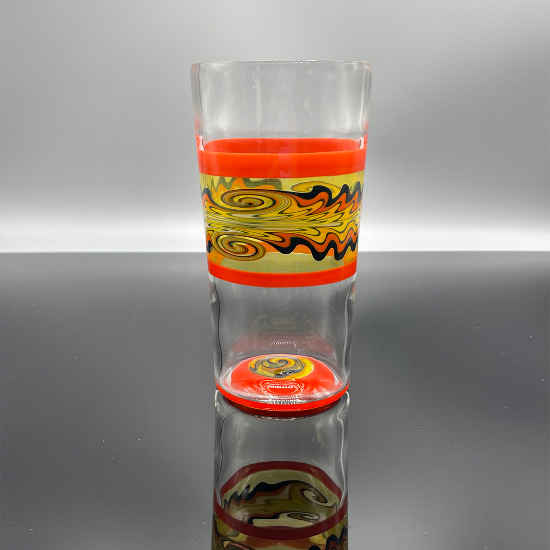 Fire themed cup with multiple sections of orange, yellow and black glass.